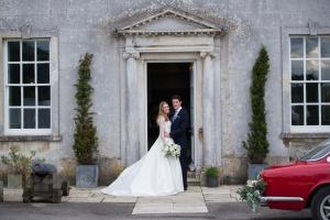 bride and groom standing outside a country house wedding venue